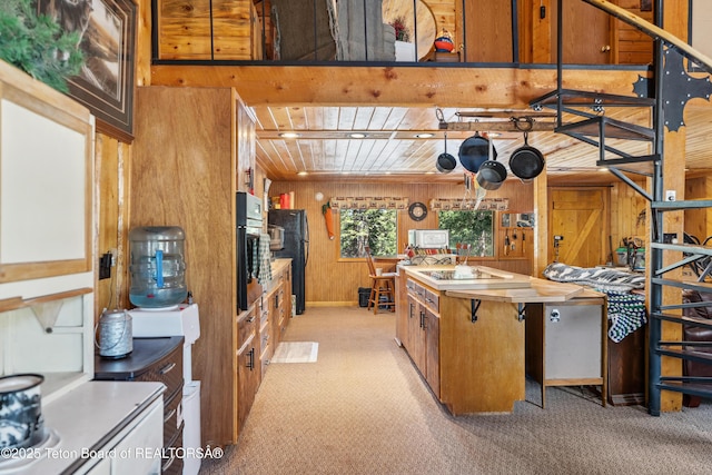 2 Porcupine Cir, Dubois, WY 82513 - kitchen featuring light carpet, wooden walls, freestanding refrigerator, oven, and brown cabinets