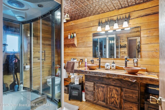 2 Porcupine Cir, Dubois, WY 82513 - full bathroom with double vanity, wood walls, a shower stall, wood finished floors, and a bath