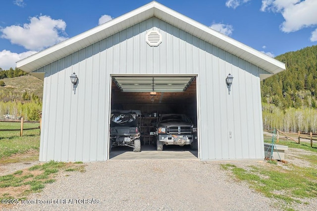 51 Buckaroo Cir, Etna, WY 83118 - detached garage featuring fence, dirt driveway, and a view of trees