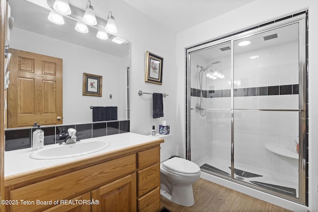 51 Buckaroo Cir, Etna, WY 83118 - full bathroom featuring a stall shower, toilet, vanity, and wood finished floors