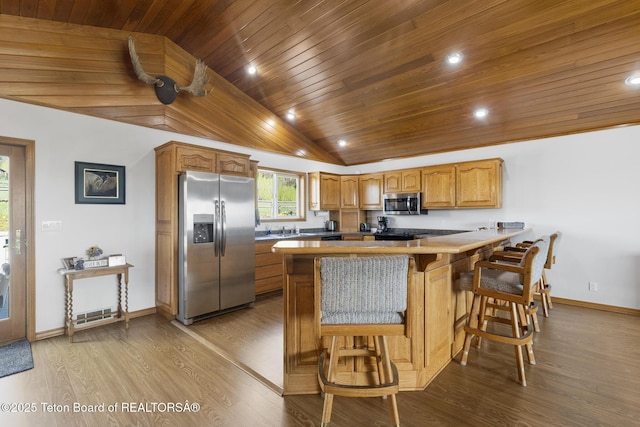 51 Buckaroo Cir, Etna, WY 83118 - kitchen with stainless steel appliances, wooden ceiling, lofted ceiling, a peninsula, and baseboards