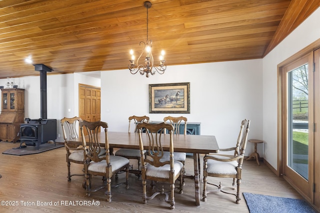 51 Buckaroo Cir, Etna, WY 83118 - dining room featuring wood ceiling, wood finished floors, a wood stove, and a chandelier