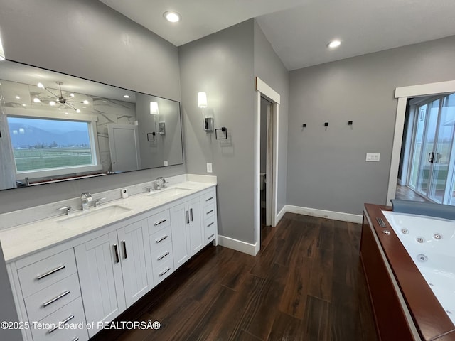 5860 Bitter Creek Rd, Afton, WY 83110 - full bathroom featuring wood finished floors, baseboards, double vanity, a whirlpool tub, and recessed lighting