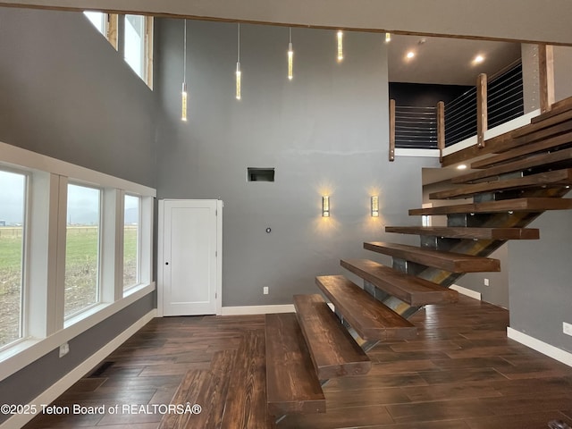 5860 Bitter Creek Rd, Afton, WY 83110 - staircase featuring baseboards, a high ceiling, and wood finished floors