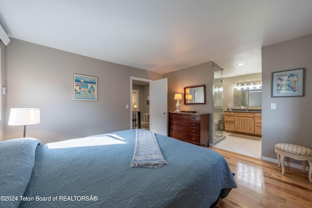 521 S Cache St, Jackson, WY 83001 - bedroom with light wood-style floors, ensuite bathroom, and baseboards