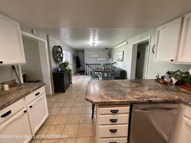 325 1st St N, Cokeville, WY 83114 - kitchen featuring dishwasher, a peninsula, a textured ceiling, white cabinets, and light tile patterned flooring