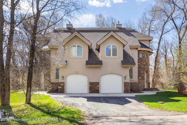 33 Willowbrook Dr, Driggs, ID 83422 - view of front of house featuring stone siding, a chimney, a garage, stucco siding, and asphalt driveway