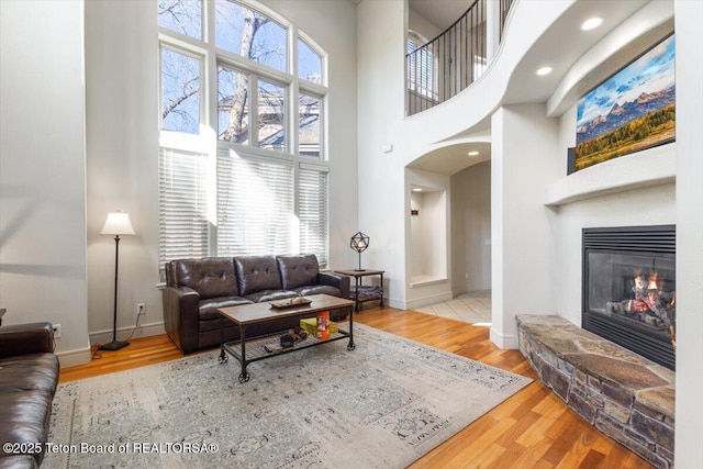 33 Willowbrook Dr, Driggs, ID 83422 - living room with arched walkways, a glass covered fireplace, wood finished floors, a towering ceiling, and baseboards