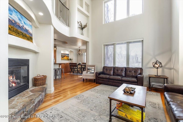 33 Willowbrook Dr, Driggs, ID 83422 - living room featuring a towering ceiling, wood finished floors, and a stone fireplace