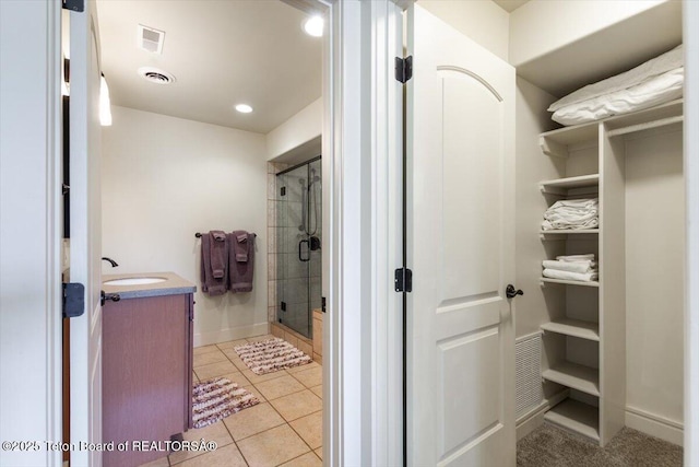 33 Willowbrook Dr, Driggs, ID 83422 - full bathroom featuring a stall shower, a spacious closet, vanity, tile patterned floors, and baseboards