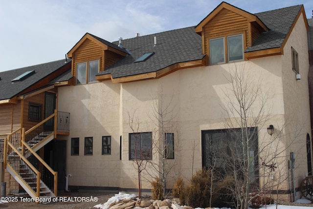 60 Flying Frog St, Dubois, WY 82513 - back of house featuring stucco siding, a shingled roof, and stairway