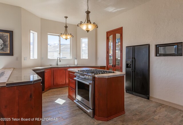 60 Flying Frog St, Dubois, WY 82513 - kitchen featuring black appliances, a sink, wood finished floors, a textured wall, and hanging light fixtures