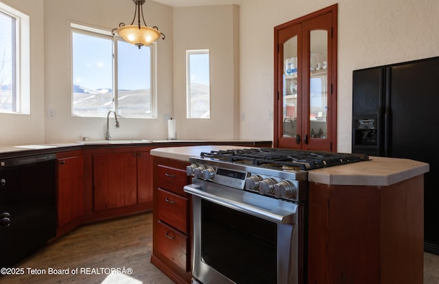 60 Flying Frog St, Dubois, WY 82513 - kitchen with black appliances, a sink, light countertops, wood finished floors, and decorative light fixtures