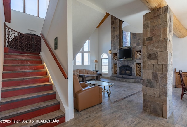 60 Flying Frog St, Dubois, WY 82513 - stairs featuring wood finished floors, a towering ceiling, and a stone fireplace