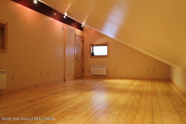 bonus room with light wood-style floors and lofted ceiling