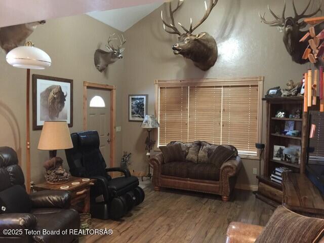 living room with wood finished floors and vaulted ceiling