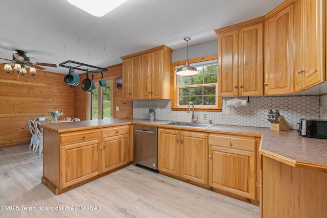 kitchen with stainless steel dishwasher, light wood-type flooring, a sink, decorative backsplash, and ceiling fan
