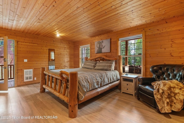 bedroom featuring light wood finished floors, wooden walls, access to outside, multiple windows, and wood ceiling