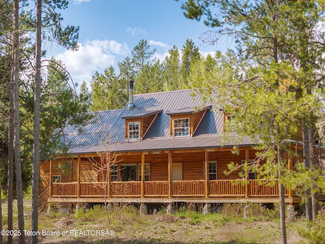 back of property featuring covered porch and metal roof