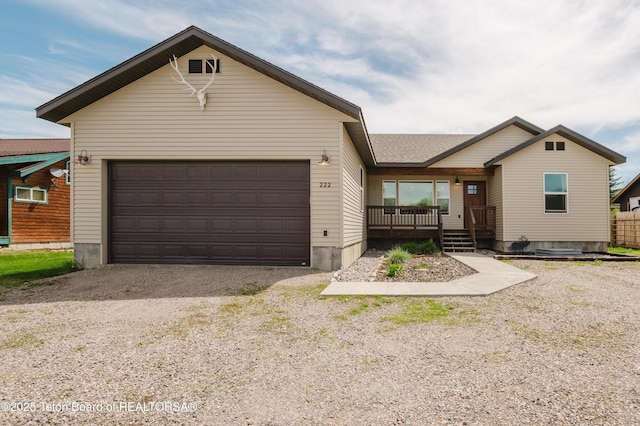 222 River Bench Rd, Alpine, WY 83128 - ranch-style home with a garage, gravel driveway, and a porch