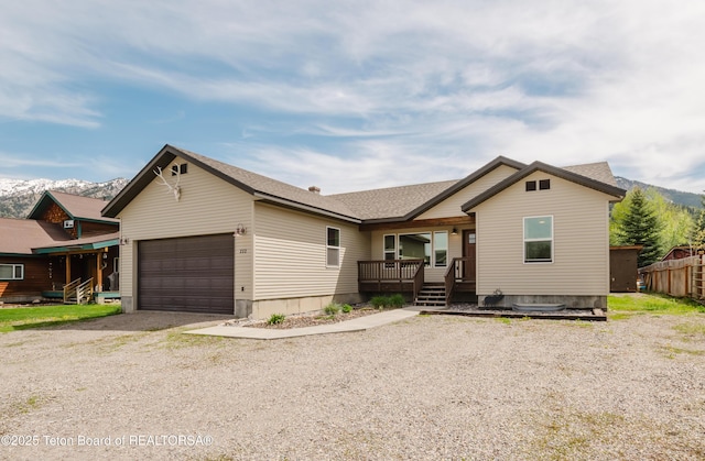 222 River Bench Rd, Alpine, WY 83128 - view of front facade with a garage, driveway, a porch, a shingled roof, and a mountain view