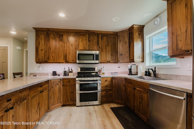 222 River Bench Rd, Alpine, WY 83128 - kitchen featuring appliances with stainless steel finishes, a sink, light wood finished floors, light countertops, and recessed lighting