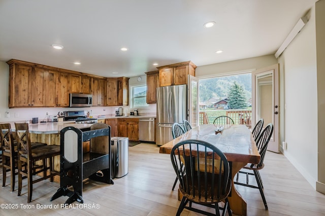 222 River Bench Rd, Alpine, WY 83128 - kitchen with appliances with stainless steel finishes, brown cabinets, light wood-type flooring, recessed lighting, and a breakfast bar area