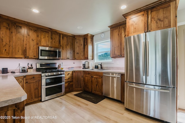 222 River Bench Rd, Alpine, WY 83128 - kitchen with stainless steel appliances, light countertops, brown cabinets, a sink, and recessed lighting