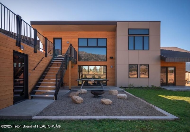 rear view of property featuring a patio, stairs, and a lawn