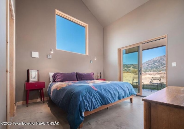 bedroom with access to exterior, high vaulted ceiling, and a mountain view