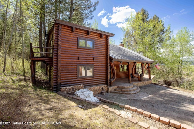 185 River Bench Rd, Thayne, WY 83127 - rear view of house with log siding, covered porch, and metal roof