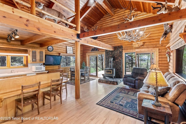 185 River Bench Rd, Thayne, WY 83127 - living area featuring wood ceiling, a wood stove, a chandelier, healthy amount of natural light, and light wood-type flooring
