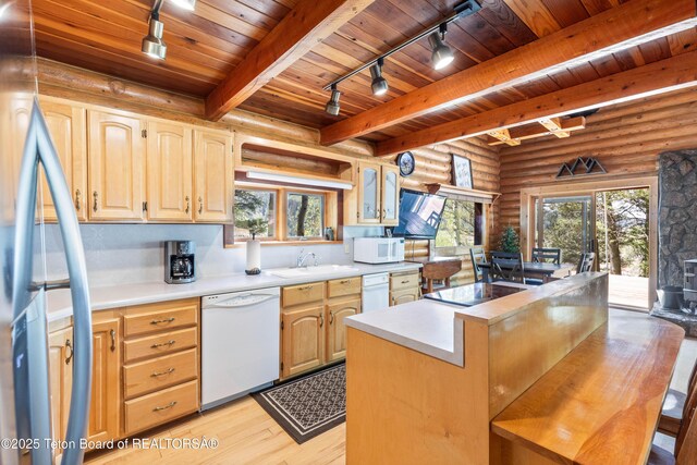 185 River Bench Rd, Thayne, WY 83127 - kitchen with white appliances, track lighting, light wood finished floors, light countertops, and rustic walls
