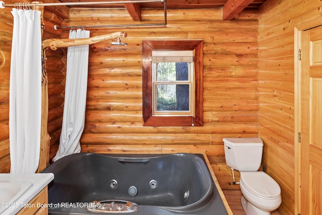 185 River Bench Rd, Thayne, WY 83127 - bathroom with a jetted tub, toilet, vanity, beamed ceiling, and rustic walls