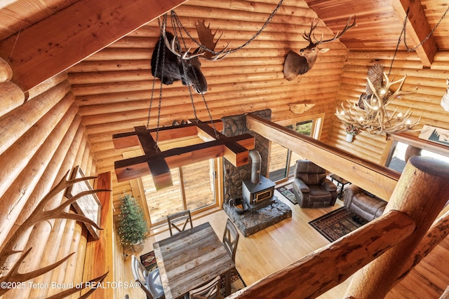 185 River Bench Rd, Thayne, WY 83127 - living area with a wood stove, wooden ceiling, rustic walls, wood finished floors, and a chandelier
