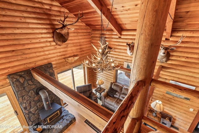 185 River Bench Rd, Thayne, WY 83127 - stairs with a wood stove, a chandelier, wood ceiling, hardwood / wood-style floors, and rustic walls