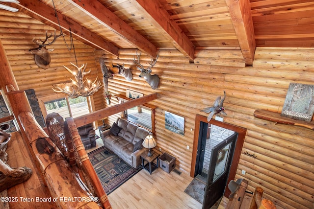 185 River Bench Rd, Thayne, WY 83127 - living room featuring beamed ceiling, wooden ceiling, a chandelier, wood finished floors, and log walls