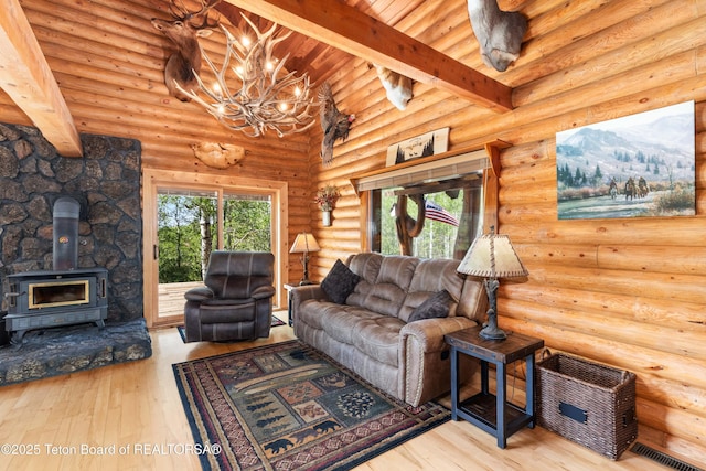185 River Bench Rd, Thayne, WY 83127 - living area featuring a wood stove, a chandelier, wood-type flooring, wood ceiling, and rustic walls
