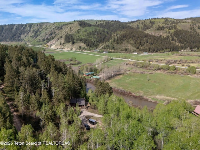 185 River Bench Rd, Thayne, WY 83127 - aerial overview of property's location with a mountain backdrop, a heavily wooded area, and rural landscape
