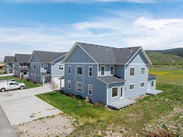 68 Alpine Trl Unit 38, Victor, ID 83455 - back of house with board and batten siding, driveway, a yard, and a shingled roof