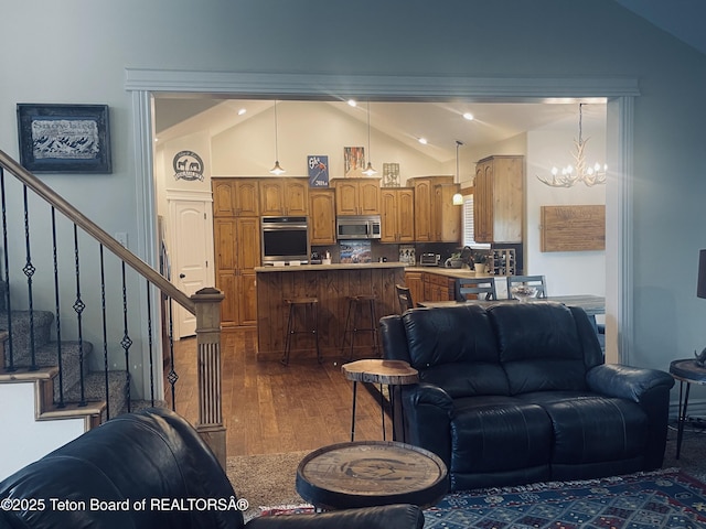61 Astorian Ln, Smoot, WY 83126 - living room featuring vaulted ceiling, a chandelier, dark wood-style flooring, and stairs