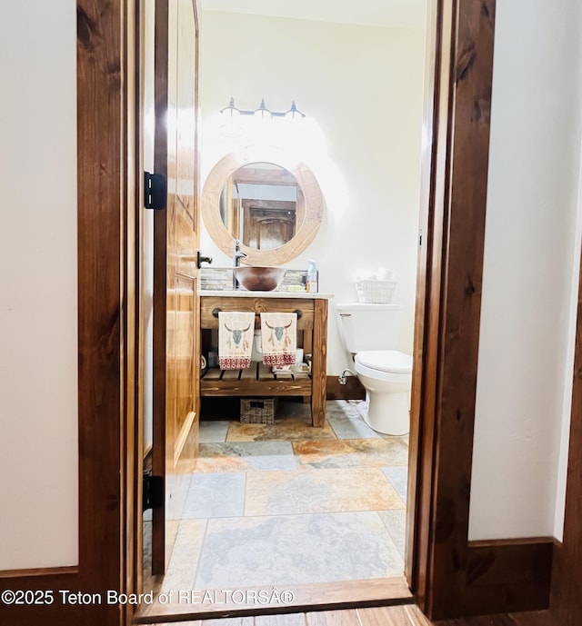 61 Astorian Ln, Smoot, WY 83126 - half bath featuring toilet, stone finish flooring, and vanity