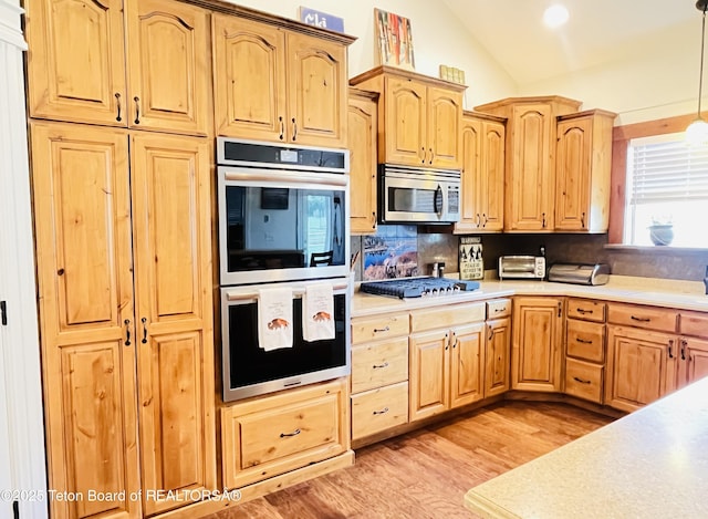 61 Astorian Ln, Smoot, WY 83126 - kitchen with appliances with stainless steel finishes, light brown cabinets, light countertops, and vaulted ceiling