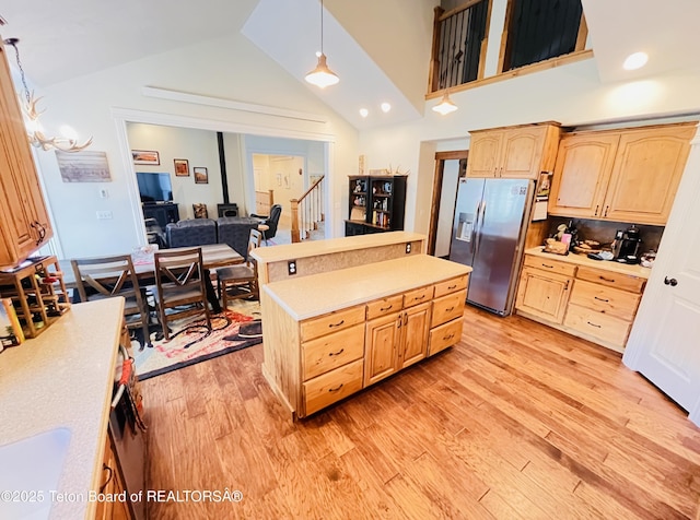 61 Astorian Ln, Smoot, WY 83126 - kitchen with stainless steel fridge, light brown cabinets, light wood-style floors, light countertops, and lofted ceiling