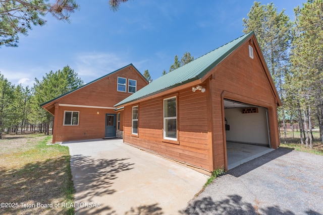 4515 Weslin Trl, Island Park, ID 83429 - view of front of property with metal roof, a detached garage, driveway, and an outbuilding