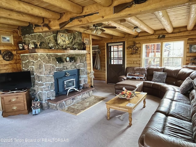 31 Cutoff Rd, Daniel, WY 83115 - carpeted living area with wood ceiling with exposed beams, rustic walls, a ceiling fan, and a wood stove