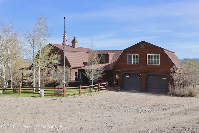 31 Cutoff Rd, Daniel, WY 83115 - view of front facade featuring a gambrel roof, driveway, metal roof, a chimney, and an attached garage
