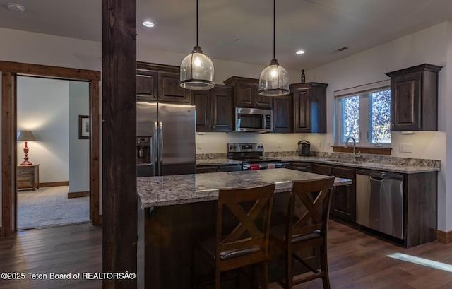 8494 Pronghorn Trl, Victor, ID 83455 - kitchen with stainless steel appliances, a sink, dark brown cabinetry, dark wood-style flooring, and a center island