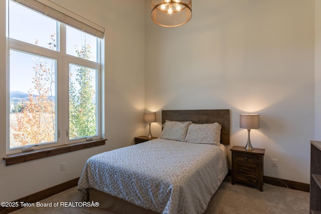 8494 Pronghorn Trl, Victor, ID 83455 - carpeted bedroom with multiple windows, a chandelier, and baseboards