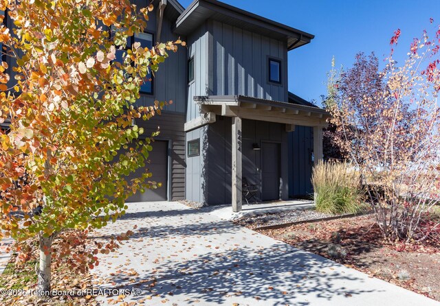 8494 Pronghorn Trl, Victor, ID 83455 - back of house featuring a garage, board and batten siding, and driveway